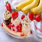 Classic banana split with chocolate, strawberry, and vanilla ice cream, topped with whipped cream and fresh strawberries.